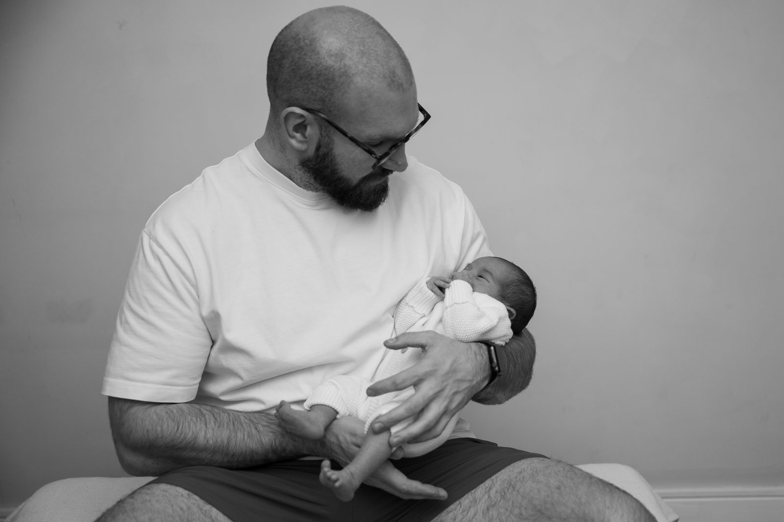 A father looking down at his newborn baby