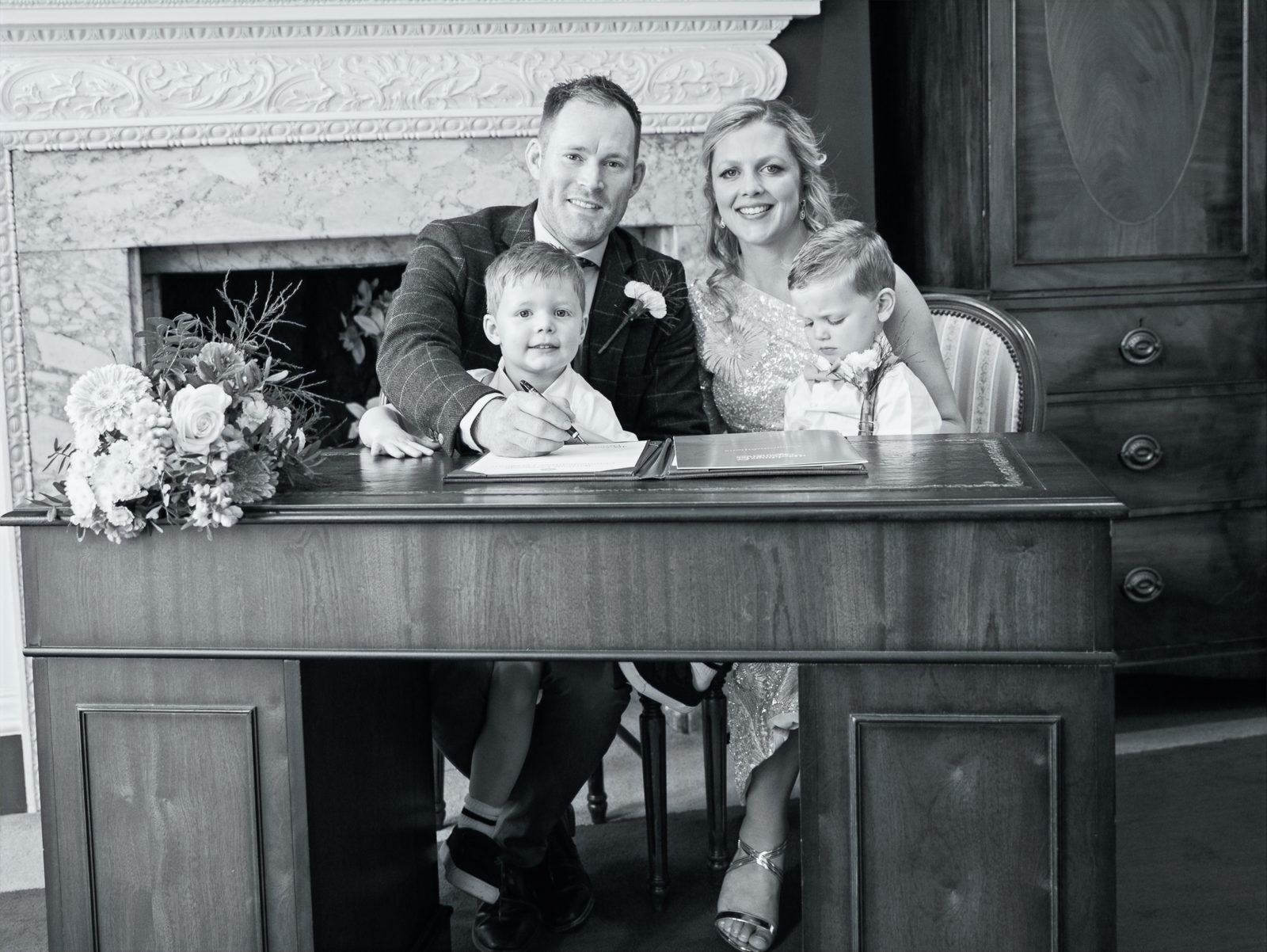 A newly married couple and two children signing the register