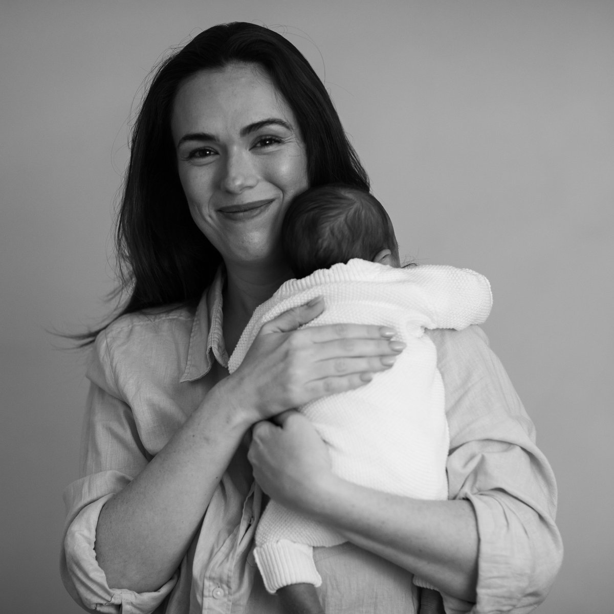 A smiling mother holding her newborn baby